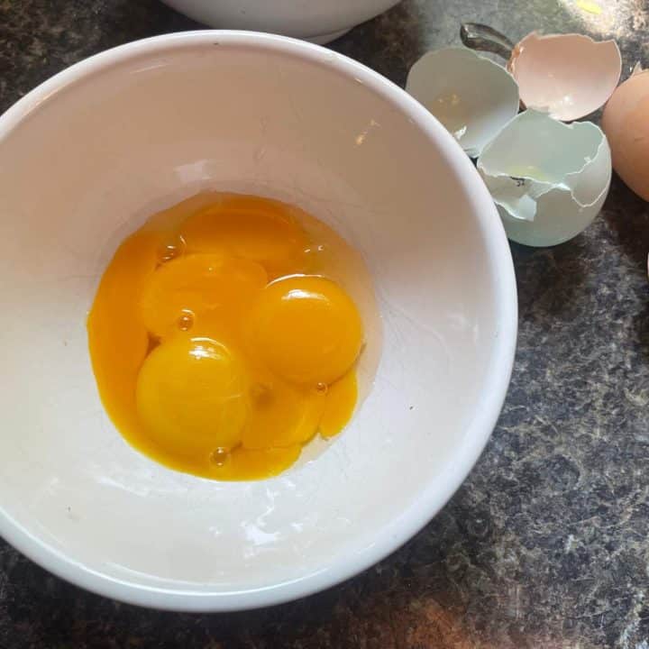 A white bowl with eggs in it.