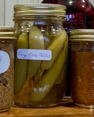 4 ball mason jars with different preservatives and golden lids.