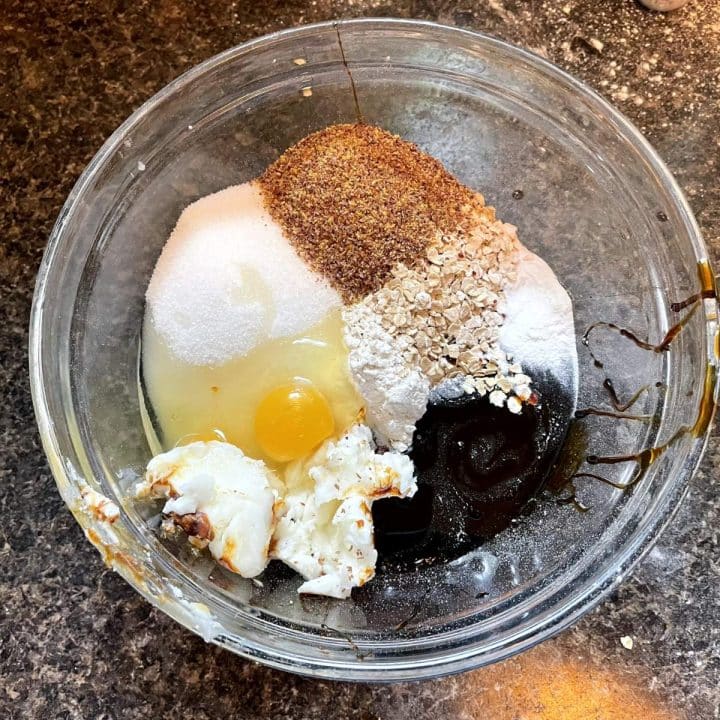 A bowl of ingredients with an egg in it.