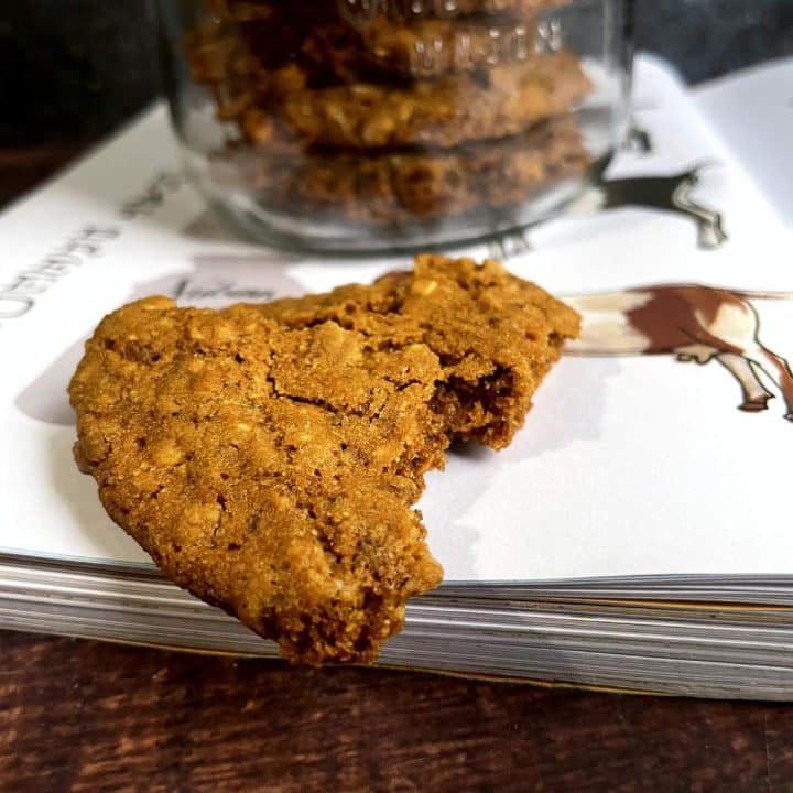 A jar of goat treats on a table next to a book.