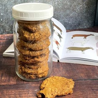A jar of goat treats next to an open book.